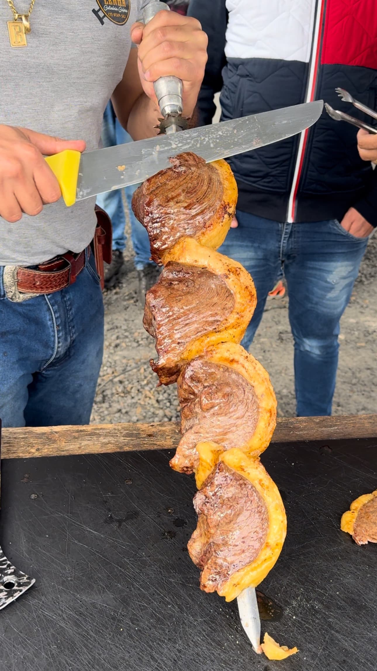 Churrasqueiro cortando carne no espeto