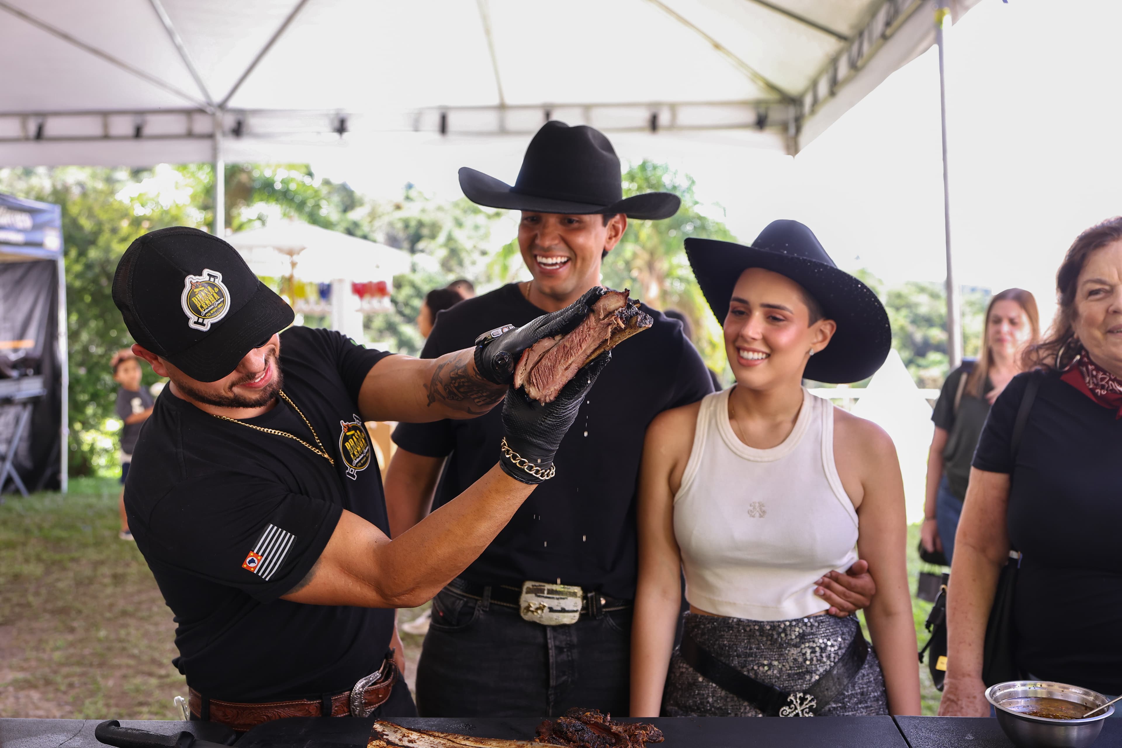 Equipe Brasa & Lenha servindo convidados em evento